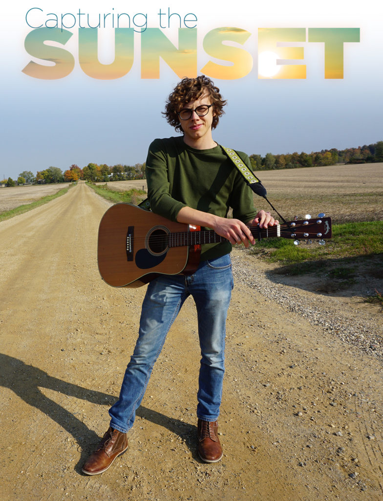 Jonathan Townley standing on dirt road with guitar