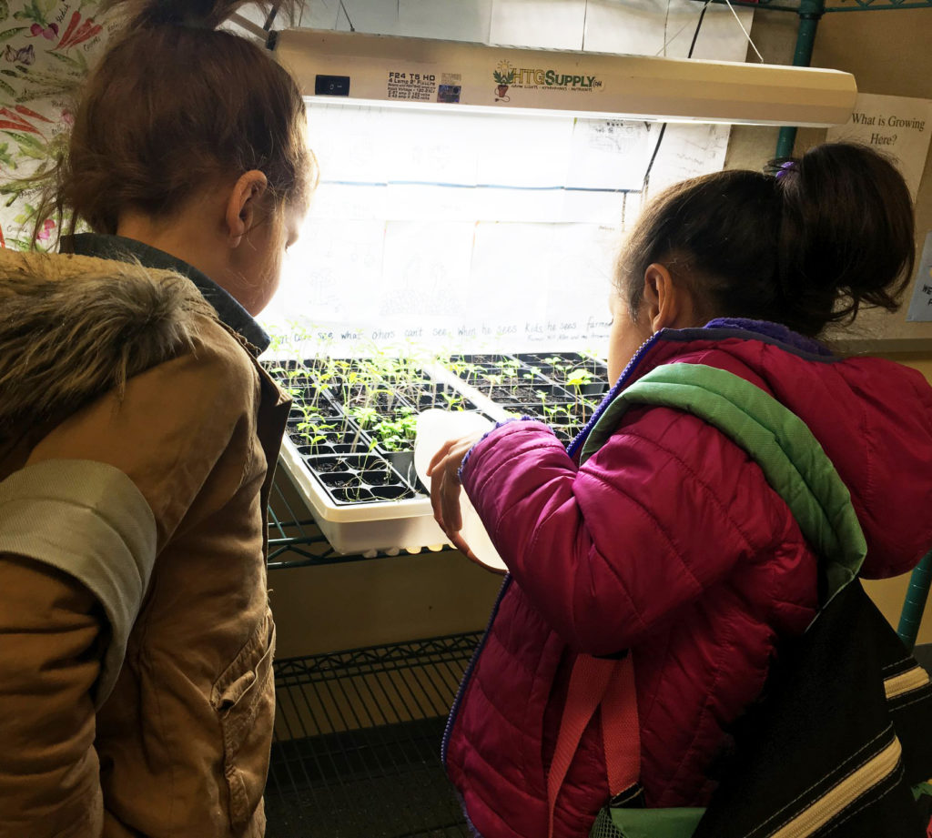 two young students watering seeds