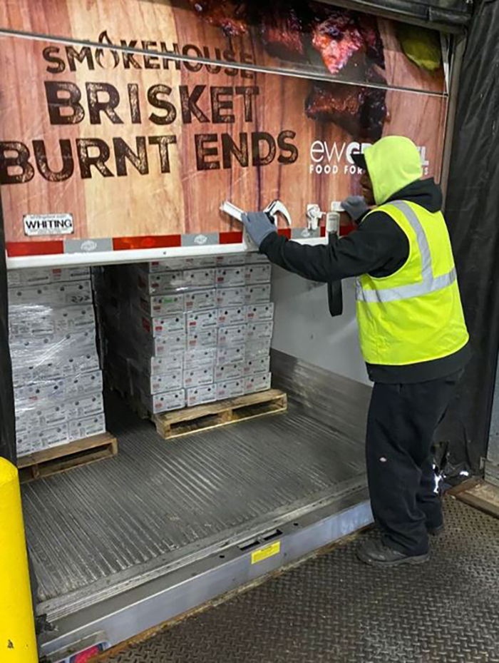 man shutting back door of delivery truck full of meat for Forgotten Harvest