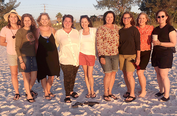 Nine women standing on beach