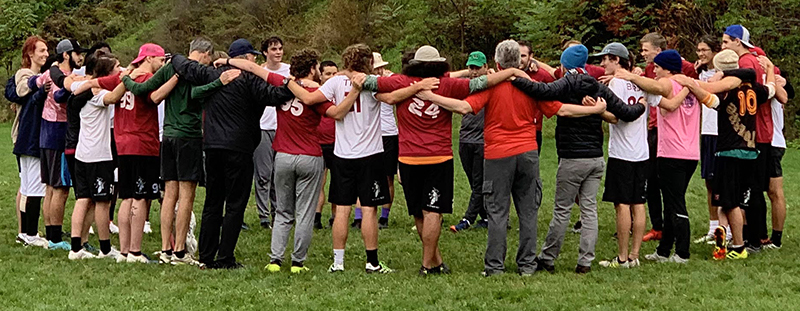 Alumni and current students in a pre-game huddle