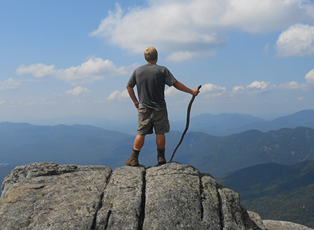 A man posing on a cliff in the Adirondacks