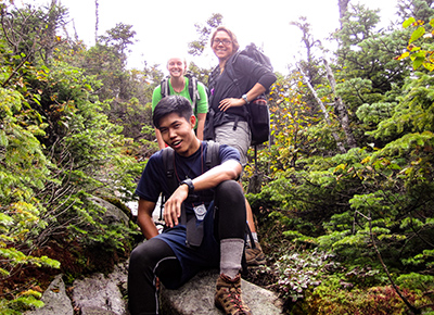 Three students posing on a hike