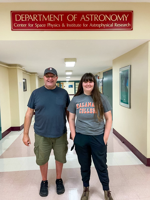 Roberts and their dad posing under a Boston University Astronomy Department sign.