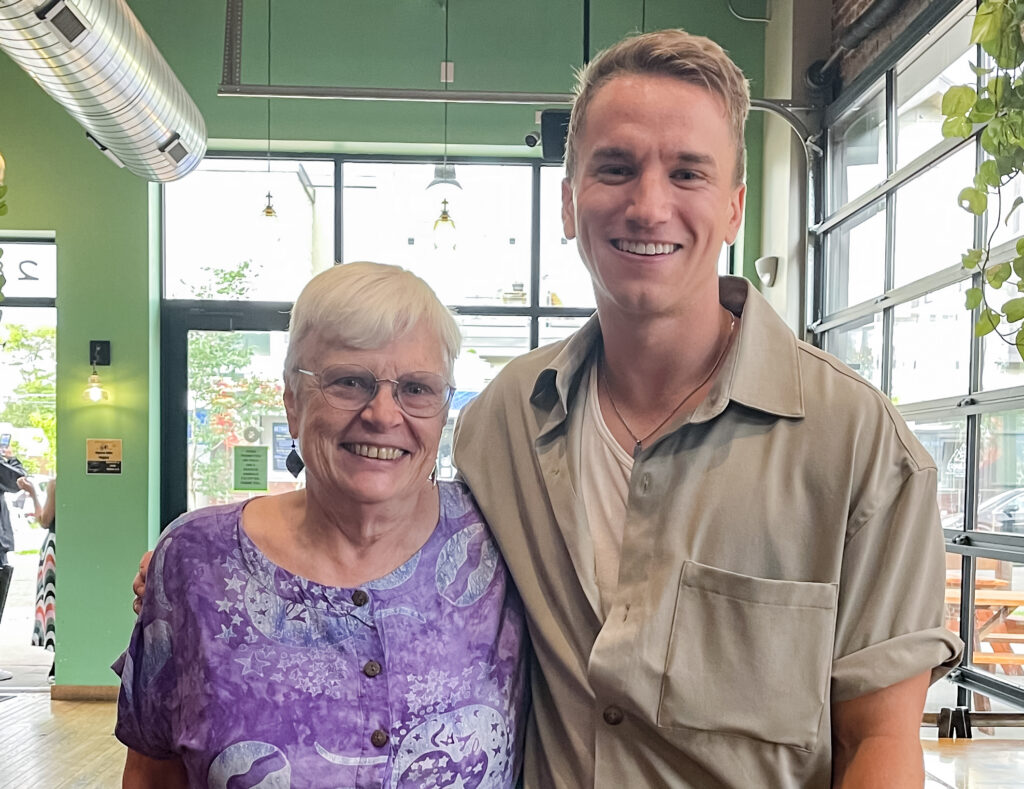 Sally Madsen '73 and Cameron Goodall '15 smiling together after a magic show.