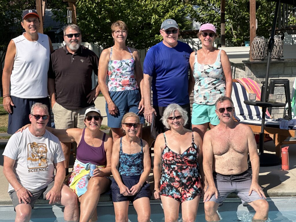 Group photo of Kalamazoo College Class of '83 alumni at a reunion, posing by a pool