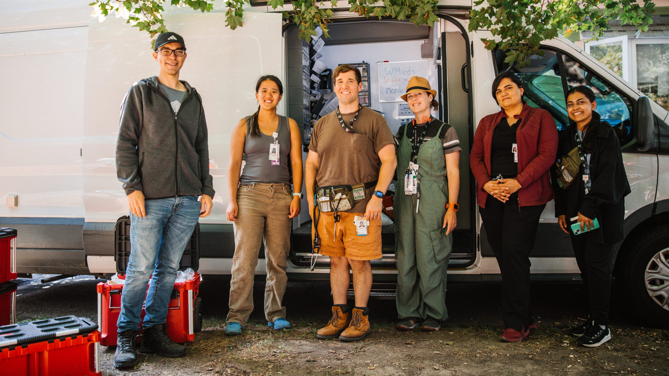 Nic Helmstetter, M.D., '10, and colleagues posing for a group photo in front of their van.