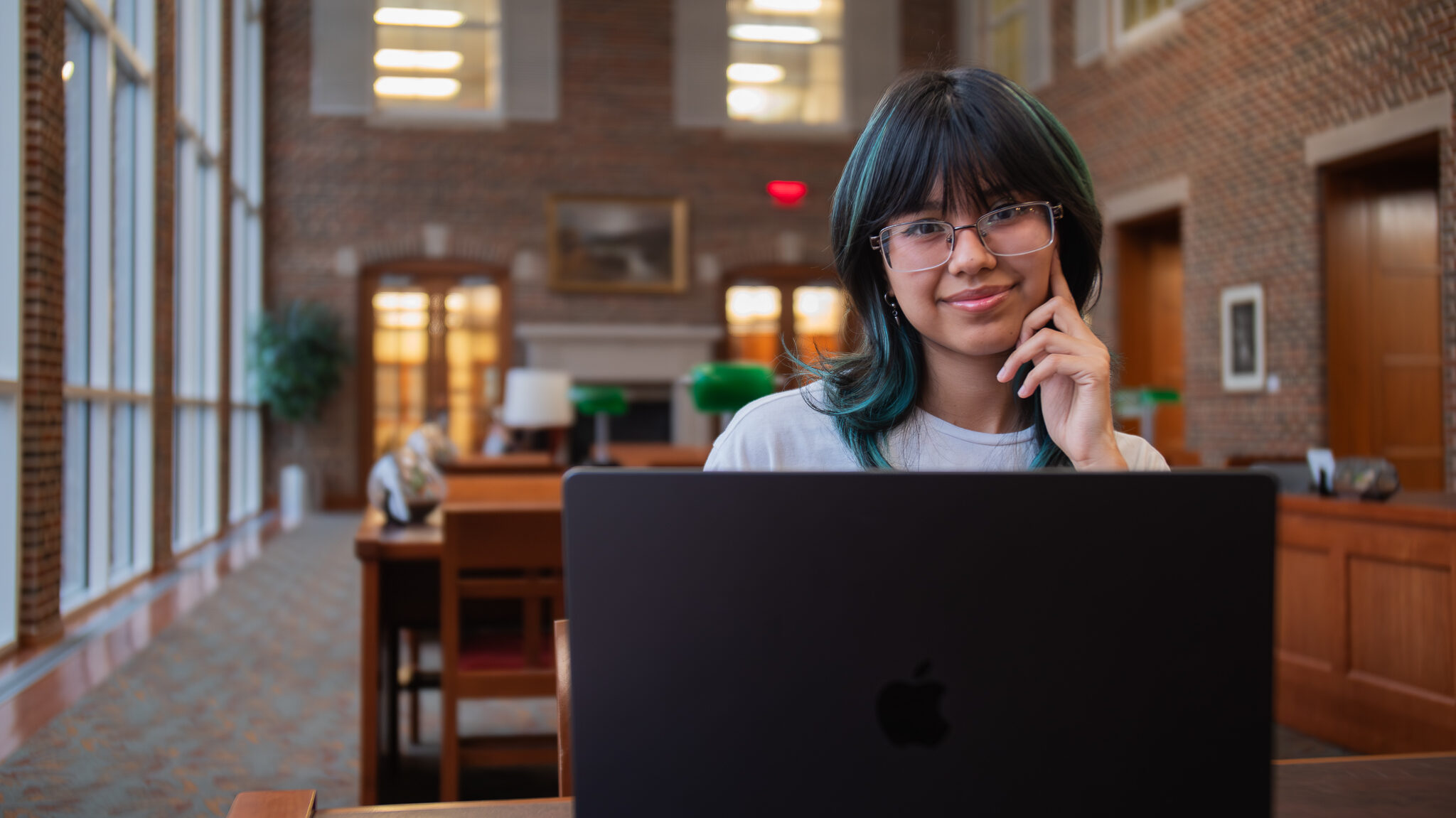 Tracy Galeana ’25 with laptop in the reading room in Upjohn Library