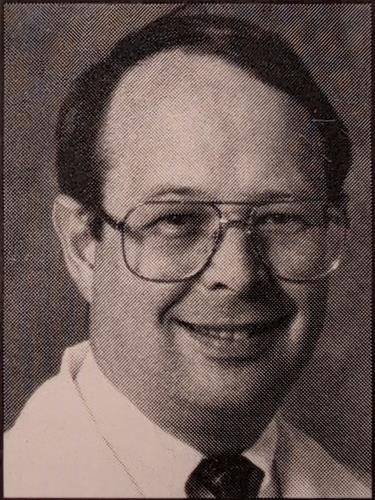 A halftone-style portrait of Duane Douglas Harrison, a man with dark hair and glasses, smiling toward the camera. He is wearing a light-colored dress shirt and a dark necktie against a dark, textured background.