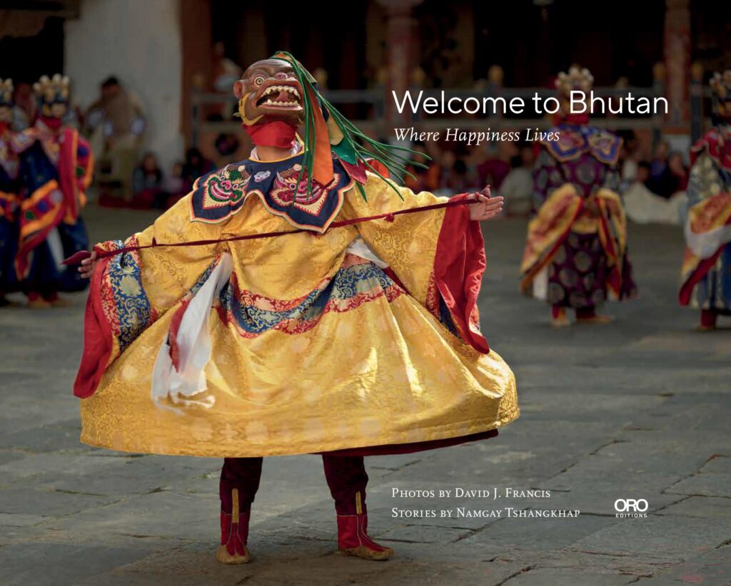 welcome to bhutan book cover featuring a person in a yellow costume